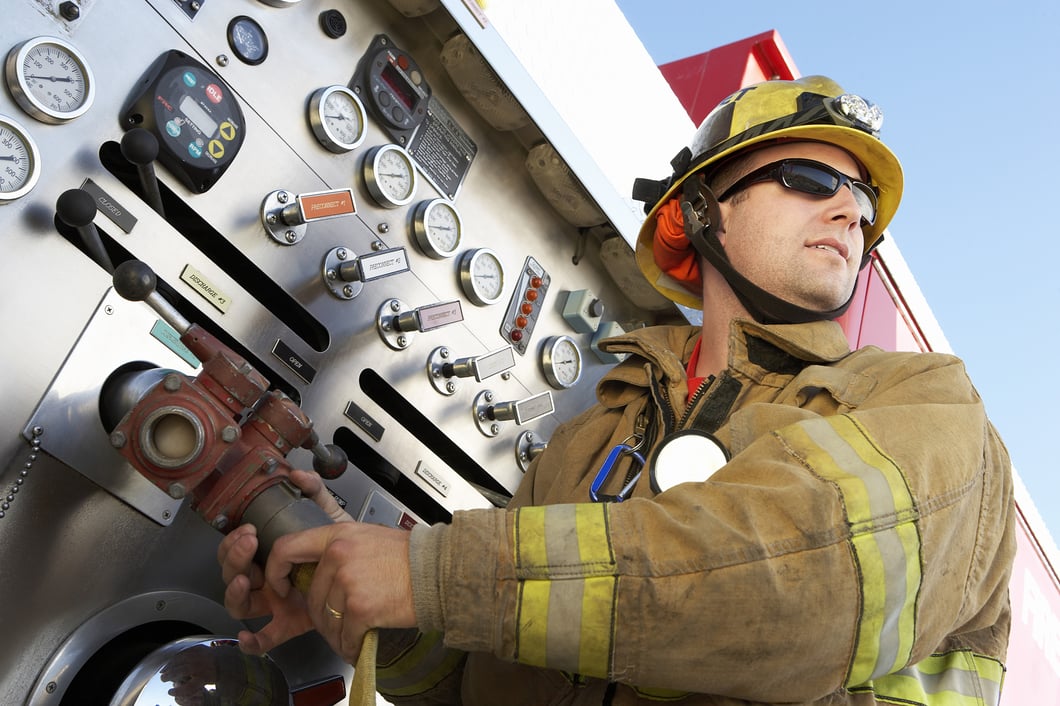 Firefighter in gear working on a firetruck